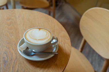 Tahta bir masanın üzerinde bir fincan kahve, yakın çekim.