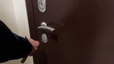 Bir adamın eli ön metal kapıyı bir anahtarla açıyor ve eve girmek için kapıyı açıyor. Yüksek kaliteli FullHD görüntüler