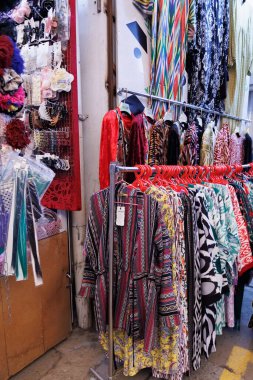 Taşkent, Özbekistan, 28 Ekim 2025. Çok çeşitli kumaş ve giysi sunan, müşterilerin ürünlere göz attığı renkli, geleneksel bir pazar. Yüksek kalite fotoğraf