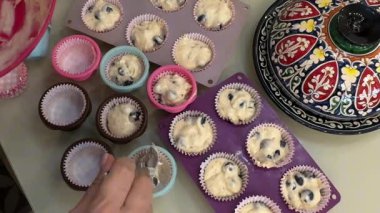 Kek yapıyorum. Kadınların elleri hamuru kaşık kaşık kâğıt kek kalıbına sokuyor. Ev yapımı. Yüksek kaliteli FullHD görüntüler