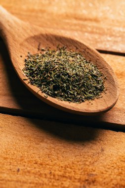 Hafif ahşap zemin üzerine bir kaşık kekik