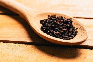 açık renkli bir tahta kaşık karanfil baharat