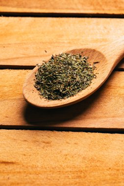 Hafif ahşap zemin üzerine bir kaşık kekik