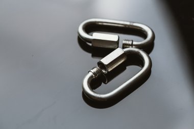 iki metal carabiner klip koyu arka plan üzerinde