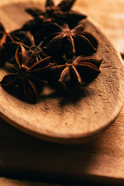 Steranijs kruiden in een houten lepel op lichte achtergrond — Stockfoto
