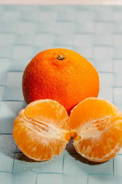 Fatias de tangerinas frescas em um fundo azul claro — Fotografia de Stock