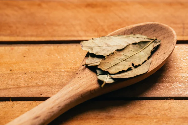 Hoja de laurel en una cuchara de madera clara de cerca —  Fotos de Stock