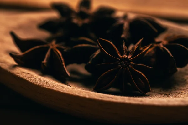 Especia de anís estrellado en una cuchara de madera sobre fondo claro —  Fotos de Stock