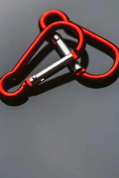 stock image several metal carabiner red on a dark background