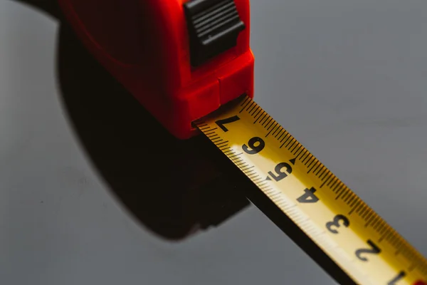 Orange construction tape measure against a dark background — Stock Photo, Image