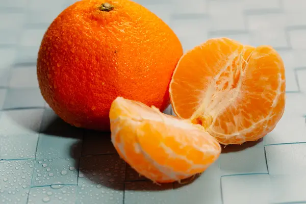 Fatias de tangerinas frescas em um fundo azul claro — Fotografia de Stock