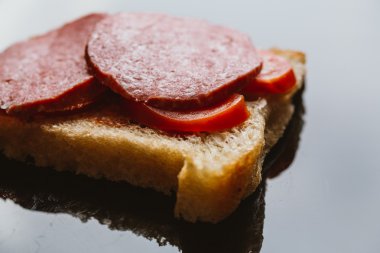 karanlık bir arka plan üzerinde füme sosisli sandviç