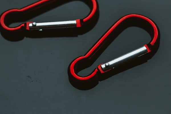 Kilka metalowe karabińczykiem czerwony na ciemnym tle — Zdjęcie stockowe