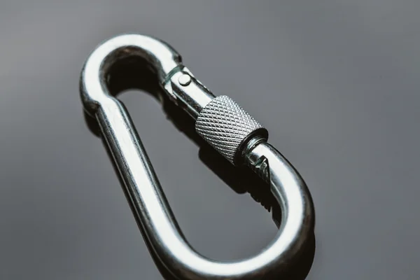 Ένα carabiner μετάλλων σε σκούρο φόντο κατοπτρισμού — Φωτογραφία Αρχείου