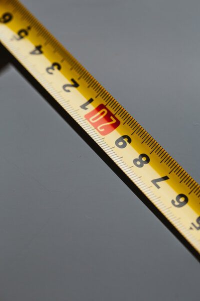 orange construction tape measure against a dark background