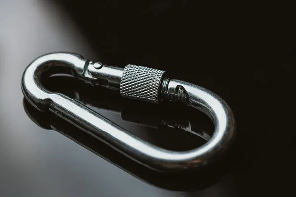 Ένα carabiner μετάλλων σε σκούρο φόντο κατοπτρισμού — Φωτογραφία Αρχείου