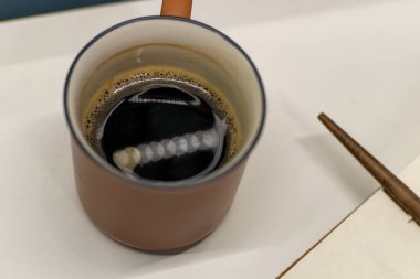 Kahve fincanı ve açık not defteriyle rahat bir masa