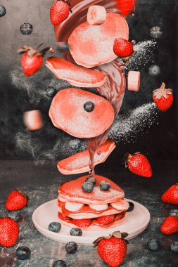 Havada yakalanmış çilekli ve muzlu gözleme. Renk, tazelik ve enerji dolu hareketli lezzetli kahvaltı öğelerini gösteren dinamik ve eğlenceli bir yemek tasarımı konsepti..