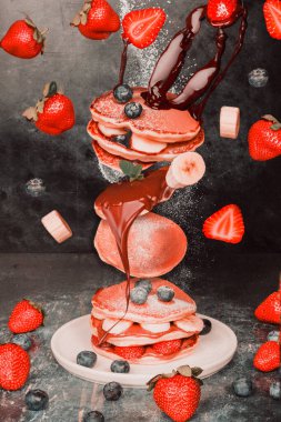 Havada uçan bir dilim kekin yer aldığı dinamik bir yemek tasarımı..