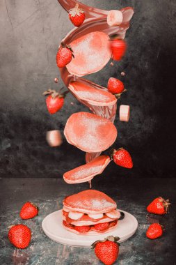 Havada yakalanmış çilekli ve muzlu gözleme. Renk, tazelik ve enerji dolu hareketli lezzetli kahvaltı öğelerini gösteren dinamik ve eğlenceli bir yemek tasarımı konsepti..