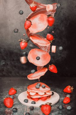 Havada yakalanmış çilekli ve muzlu gözleme. Renk, tazelik ve enerji dolu hareketli lezzetli kahvaltı öğelerini gösteren dinamik ve eğlenceli bir yemek tasarımı konsepti..