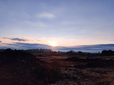 Ufukta güzel bir gün doğumu parlıyor ve gökyüzünü bitkilerle boyuyor. Seyahat, özgürlük, doğa, macera ve ilham verici manzaralar için ideal.
