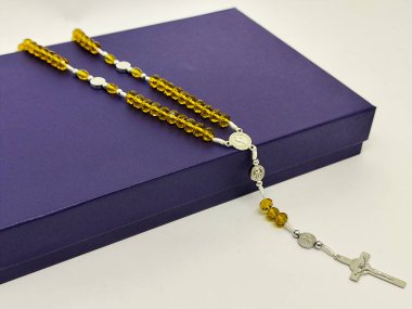 Saint Benedict 'in renkli kristal tespihi. Madalya ve haçla birlikte. Katolik bağlılığı, ruhaniyet, dua, inanç ve dini ürün fotoğrafçılığı için mükemmel.