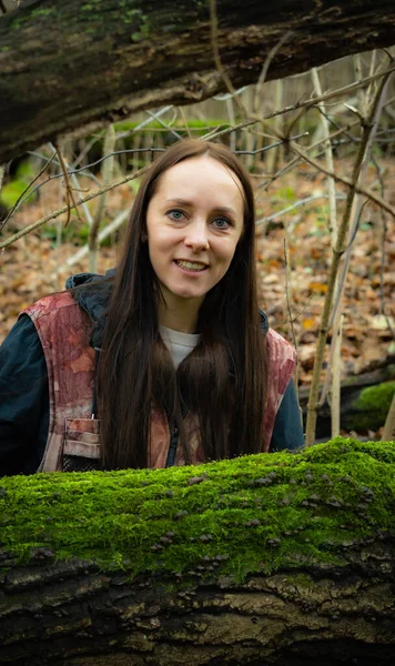 Düşen yosun ağacının yanındaki ormanda oturan kız doğayı ve orman atmosferini sakinleştirdi.