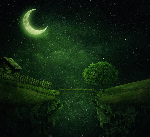 Country image with a wood bridge connecting two hills. Idyllic view of a old cabin with fence and a tree near the cliff in a starry, magic night