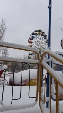 Dikey çekim terk edilmiş eğlence parkı. Eski, paslı dönme dolap ve hız treniyle kaplı. Kar, karanlık sahne, hayalet ve eğlence için insan olmayan boş bir atlıkarınca. Karlı kış günü