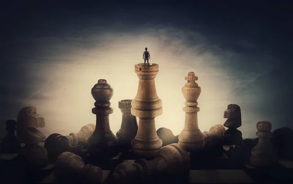 棋手取得了成功 一个身材矮小的人站在棋盘顶上 站在巨大的棋子中间 这是一个超现实和概念性的场景 克服障碍 胜利和商业领导力隐喻 — 图库照片