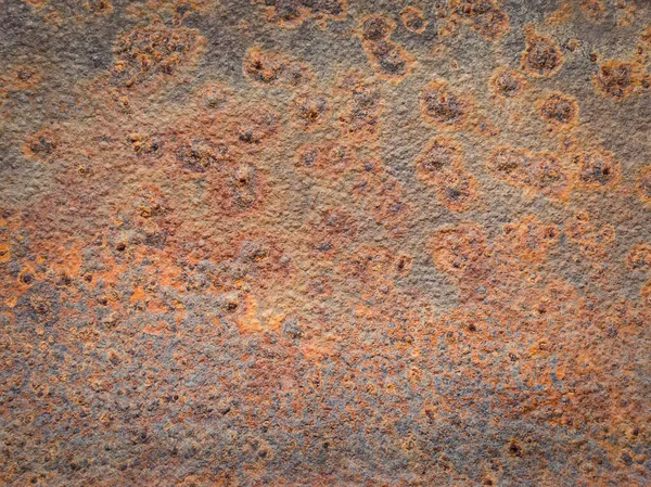 Rusty and rotten metallic structure surface. Old grungy, weathered tin sheet decay. Abstract details of weathered construction element. Dirty corrosion texture background with orange rust dots