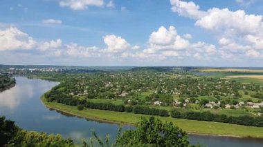 Moldova 'nın Soroca kenti yakınlarındaki Nistru nehir kıyısına yüksek açı, yükseklik manzarası. Yeşil vadide dosyalanmış küçük evlerle panoramik bir manzara.