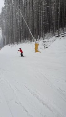 Ukrayna Karpatya dağlarındaki Bukovel kayak merkezinin karlı yamacında kayak yapan insanlar. 