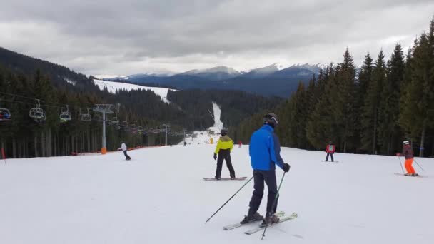 在乌克兰喀尔巴阡山脉布科维尔滑雪胜地雪坡上滑雪的人 — 图库视频影像