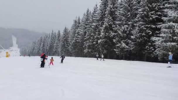 ウクライナのカルパチア山脈のブコヴェルスキーリゾートの雪の斜面に人々がスキー — ストック動画
