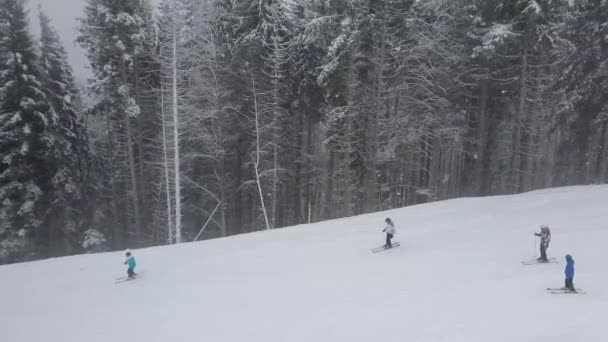 ウクライナのカルパチア山脈のブコヴェルスキーリゾートの冬の雪の斜面に人々がスキー — ストック動画