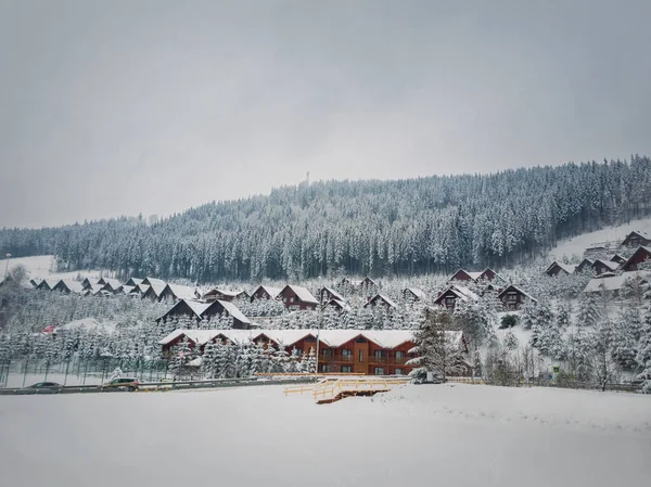 ブコヴェルスキーリゾート 寒い冬の日に雪で覆われた町のキャビンホテル ウクライナのカルパチア山脈での休暇と休暇の目的地 村の木造住宅への雪景色のシーン — ストック写真