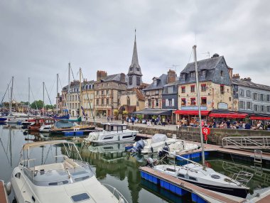 Honfleur, Normandiya, Fransa - 30 Mayıs 2025 Honfleur Vieux Bassin limanı durgun suya demirlemiş tekne ve yatlar ve arka planda renkli binalar