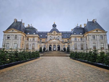 Maincy, Fransa - 11 Aralık 2025 Chateau de Vaux-le-Vikont 'un parke bahçeli büyük cephesi. Güzel Barok mimarisi kış tatili için küçük yeşil ağaçlarla süslenmiş.