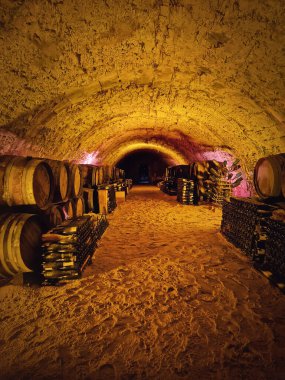 Az aydınlatılmış, tarihi mahzende, tuğladan yapılmış tavanı var. Meşe fıçıları ve istiflenmiş şarap şişeleri kumlu zemini kaplıyor. Sessiz yeraltı atmosferinde bağlar serin, kırsal sessizlikte