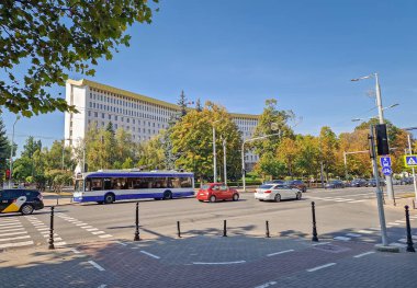 Chisinau, Moldova - 24 Eylül 2025 Moldova Cumhuriyeti parlamento binası, yoldan geçen arabalar ve tramvaylar ile dolu cadde trafiği manzaralı