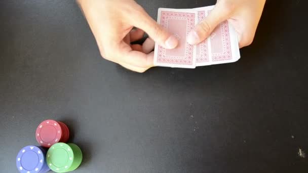 Человек, играющий в покер на черной доске — стоковое видео