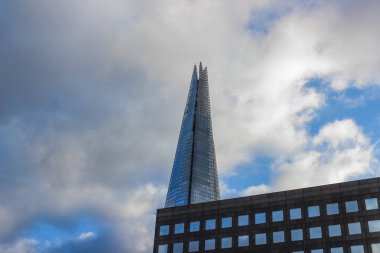 Londra, Birleşik Krallık - 25 Aralık 2025: Londra 'da cam bir gökdelen olan Çömlek bulutlu bir gökyüzüne yükselir. Bu sembolik simge karanlık bir ofis binasının üzerinde modern İngiliz mimarisini gözler önüne seriyor..