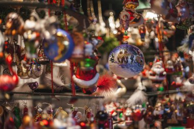 Almanya 'nın Köln kentindeki Noel Pazarı' nda küçük geleneksel dükkanlarda takılan farklı Noel süslemeleri, figürler ve takılardan oluşan bir grubun yakın çekimi. Noel süsü ve ağaç için küçük hediyelerin yakın çekimi.