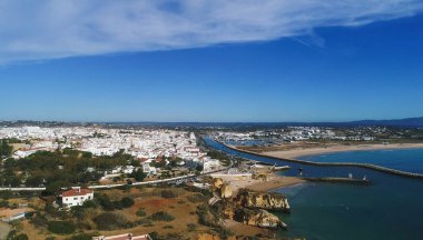Altın kayalıkların, kumlu kaya oluşumlarının ve Portekiz 'in Lagos kentindeki Atlantik kıyısındaki ünlü seyahat yerlerinin hava manzarası. Ribeira de Bensafrim ile Tatil Şehri 'nin İHA görüntüsü.