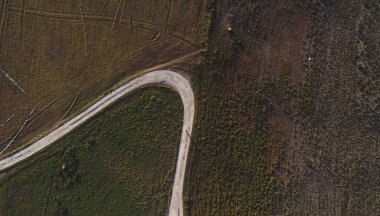 İnce yolu keskin virajlı yeşil manzaralı drone manzarası ve yolda tek başına duran tanınamaz bir kişi. Portekiz 'in Alentejo bölgesinde manzara yükseldi.