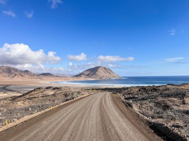 Şili 'deki Ulusal Parc Pan de Azcar boyunca uzanan güzel manzara manzarası ve toprak yol. Bu doğal alan eşsiz çöl bitkilerini, dramatik uçurumları, plajları ve el değmemiş sahil manzaralarını sergiliyor. Yolculuk için mükemmel..
