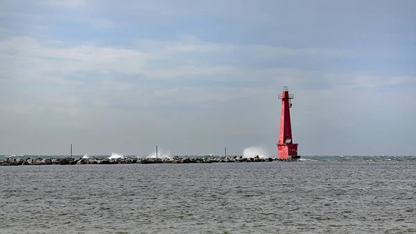 Muskegon Michigan 'da rüzgarlı bulutlu bir günde kırmızı güney dalgalı deniz feneri