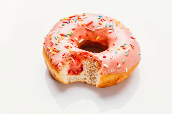 bitten donut with strawberry cream on a white background